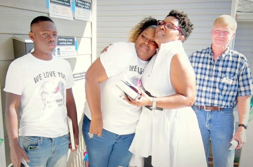 Lakesha Beasley (left) with her coach, Robin Stanley (right), and Habitat Construction Supervisor, Scott Baynard, at her home dedication.